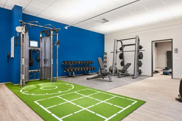 Fitness room Fitness studio with exercise equipment and green carpeting