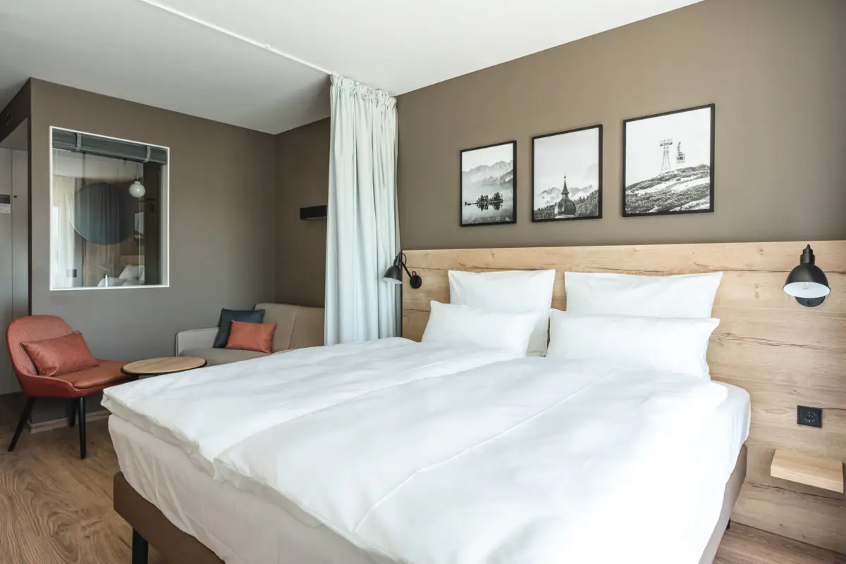 Double room A bed with white sheets and a chair.