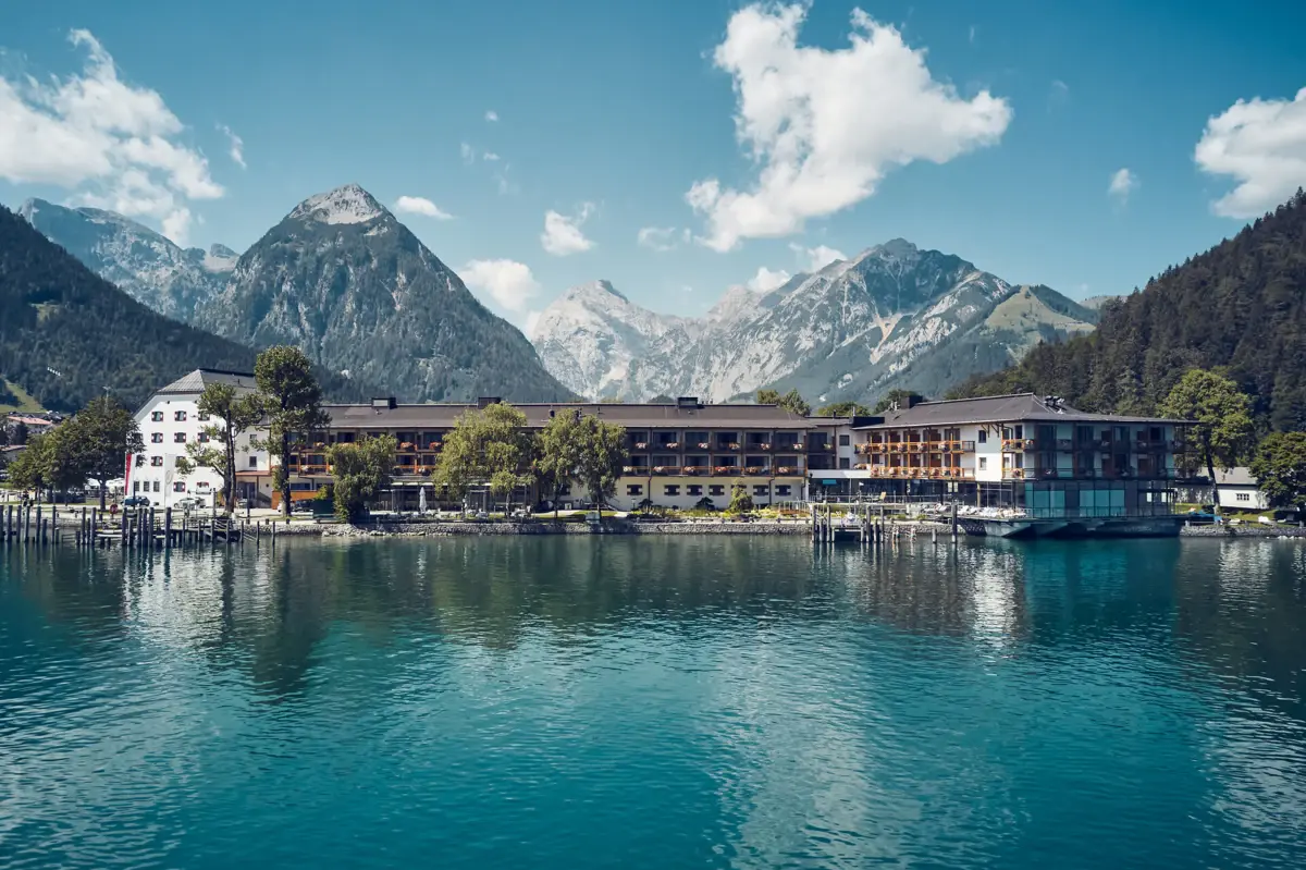 A building next to a body of water with mountains in the background.