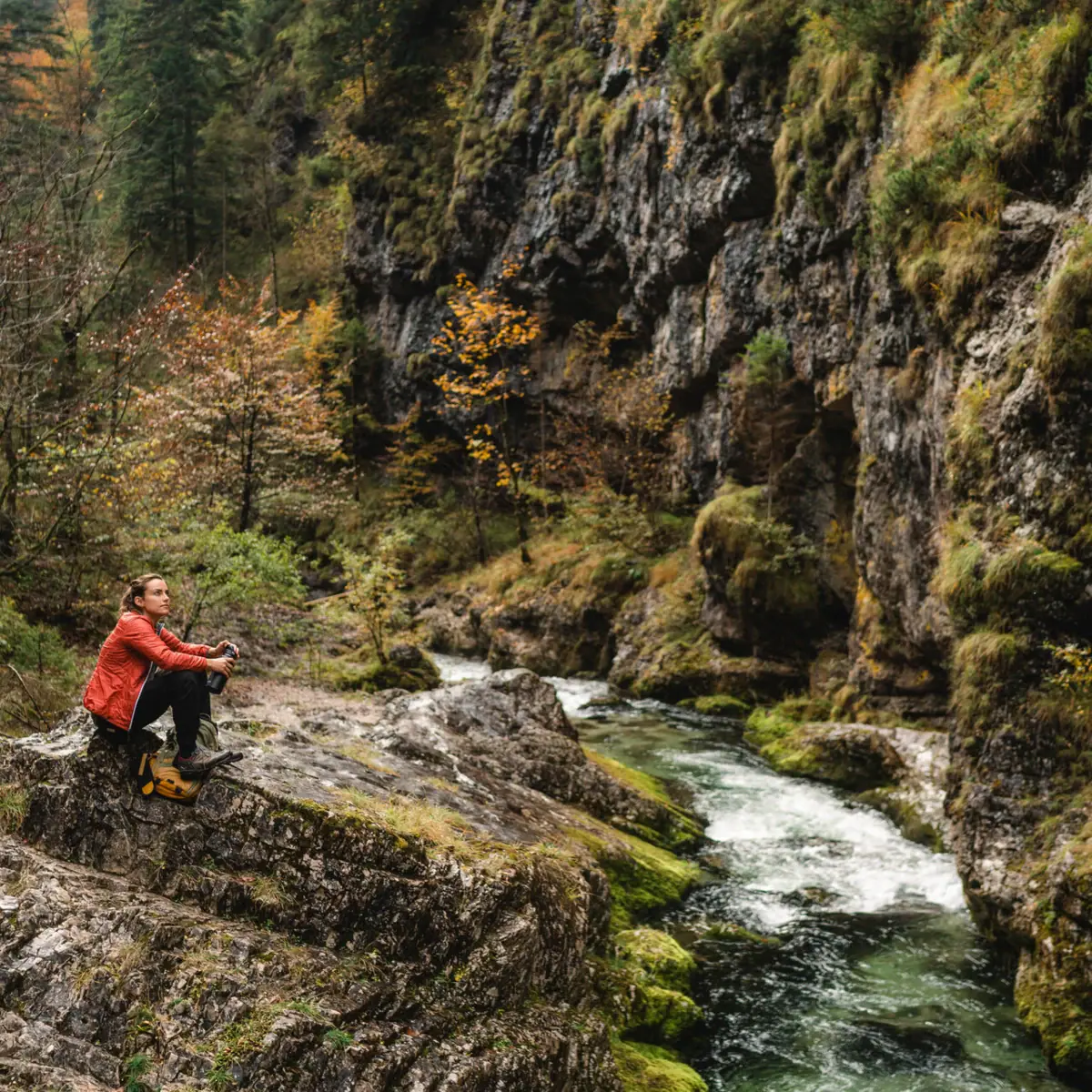 Weißbach Gorge Walk A woman is sitting on a rock by the river in the Weißbach Gorge.