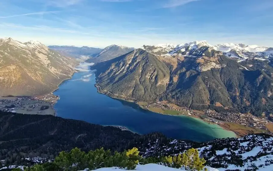 Lake Achensee in a valley surrounded by mountains and a diverse landscape.