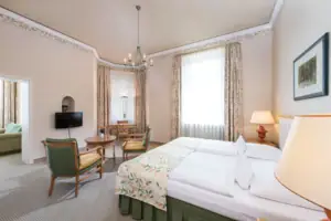 Suite A room with a bed and chairs.