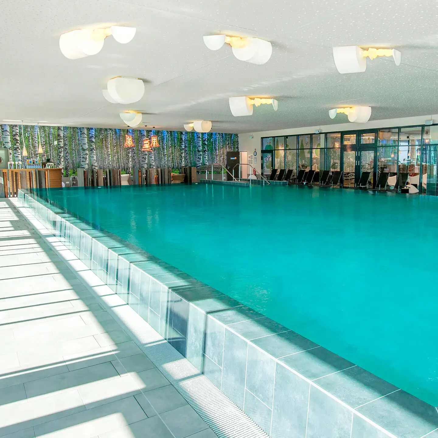 Pool at the aja Bad Saarow A swimming pool with chairs and tables.