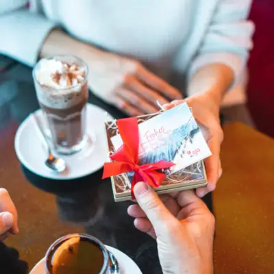 One person is holding a gift box with a red ribbon.