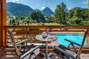Double room A table and chairs on a balcony overlooking a pool.
