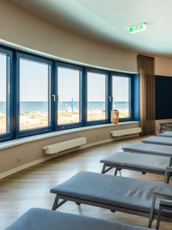 A room with chairs and large windows.