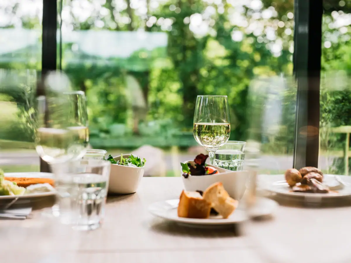 A table with various dishes and wine glasses.