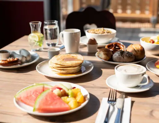 A table with plates full of food and drinks.