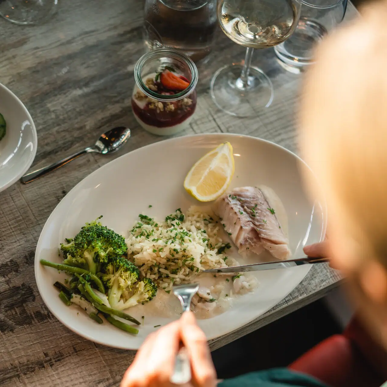 Fish dish A person eats from a plate of food.