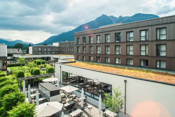 Terrace A building with a roof, tables and chairs outside under a cloudy sky.
