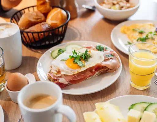 Breakfast A plate of breakfast food with tableware on a table.