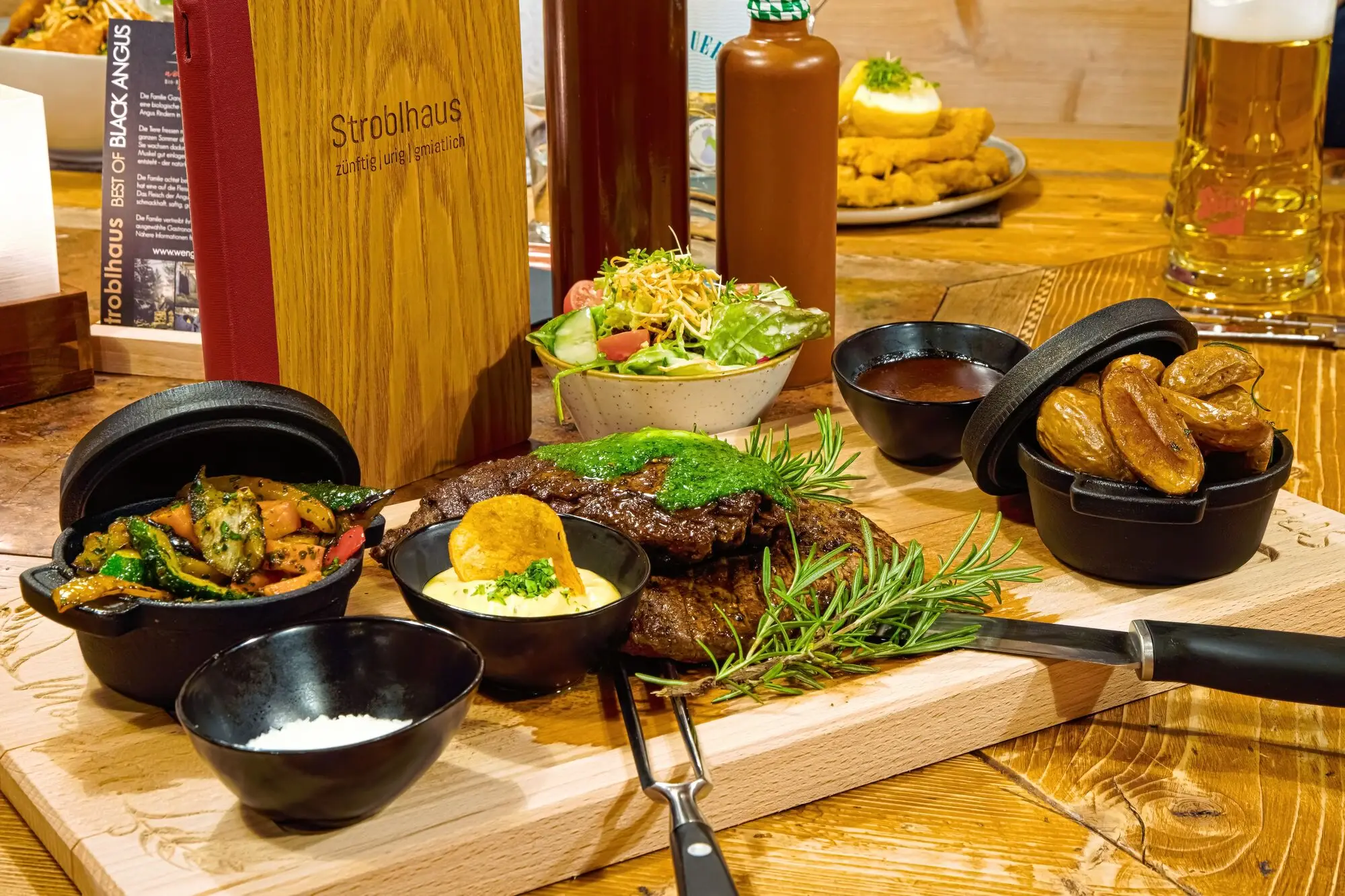 A table with food, crockery and a bottle in an interior room.