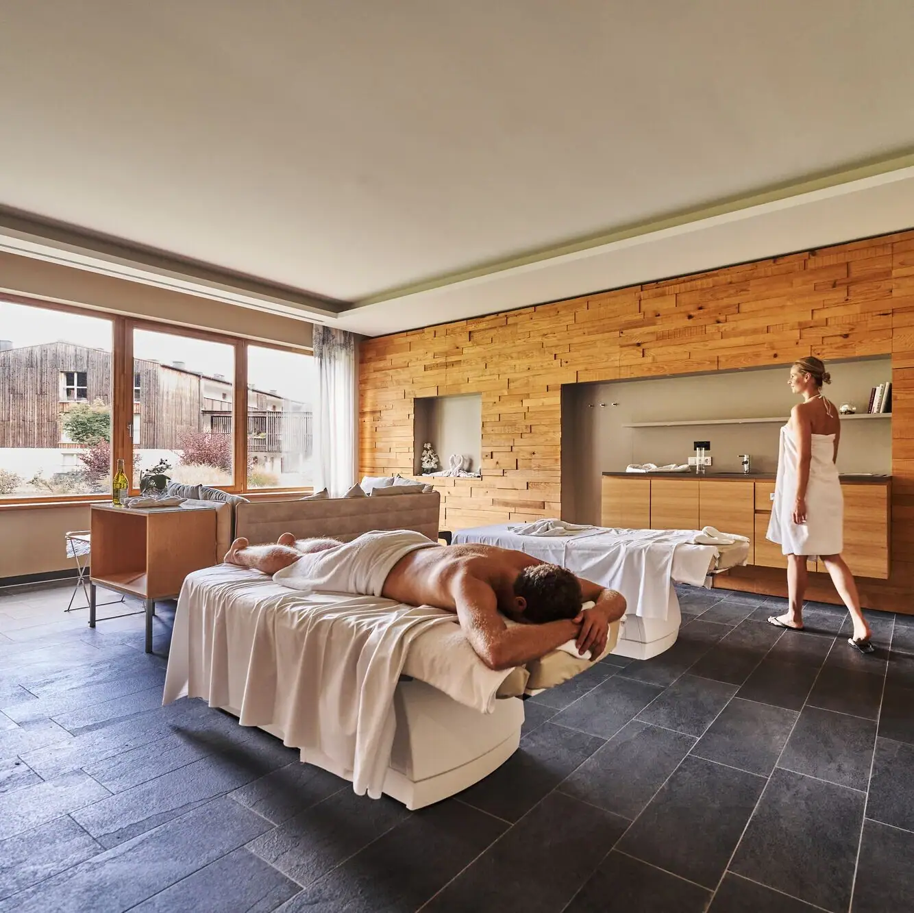 SPA Suite A man lies on a couch while a woman stands behind him.