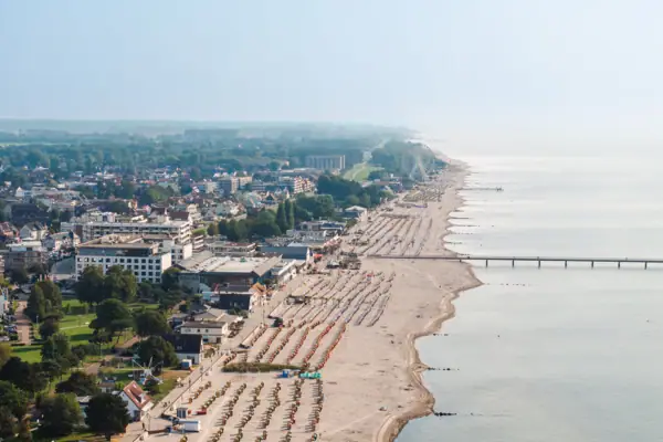 Strand mit vielen Menschen und Gebäuden aus der Vogelperspektive.
