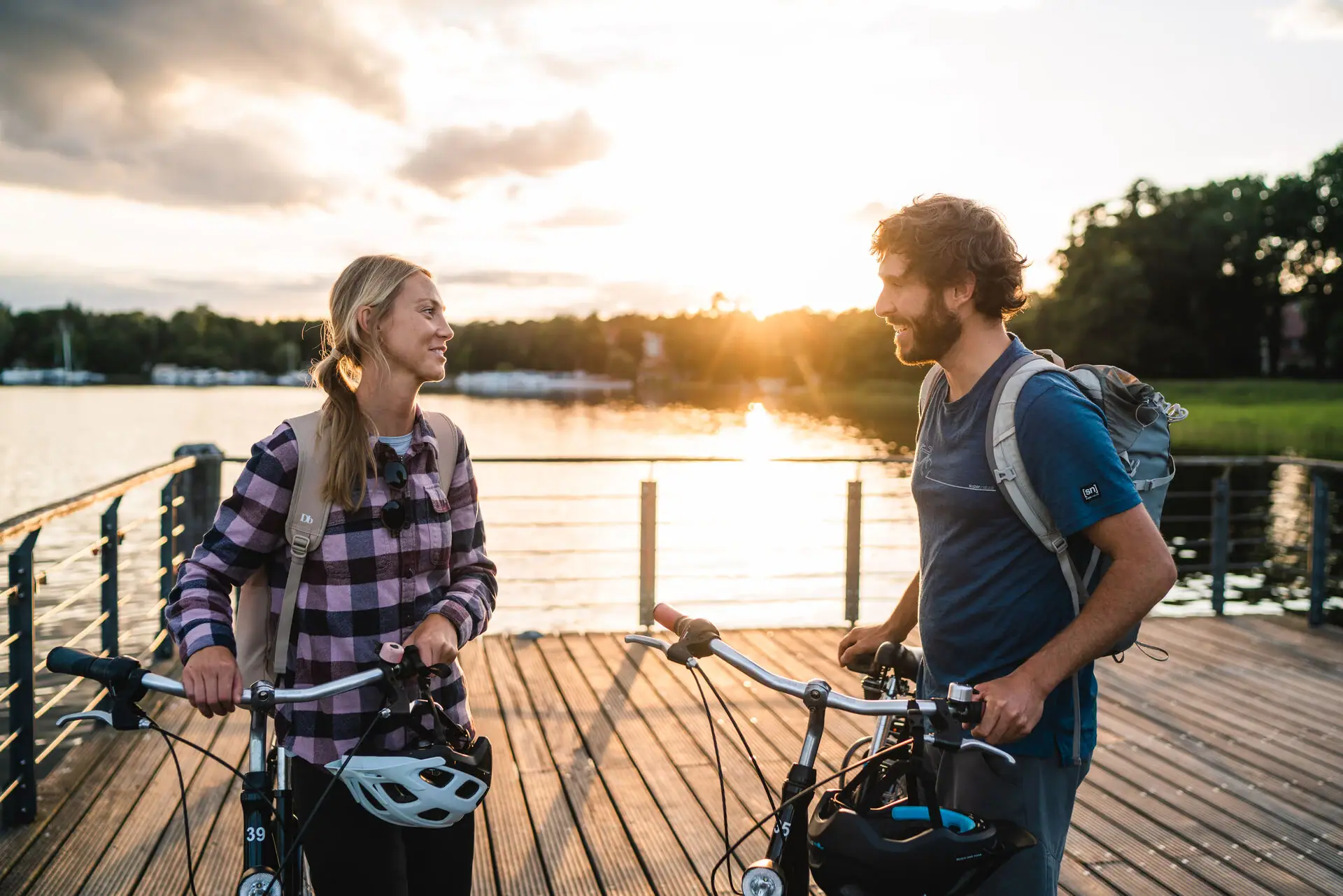 Cycle tour around Scharmützelsee A man and a woman are standing on a jetty in front of a lake with bicycles.