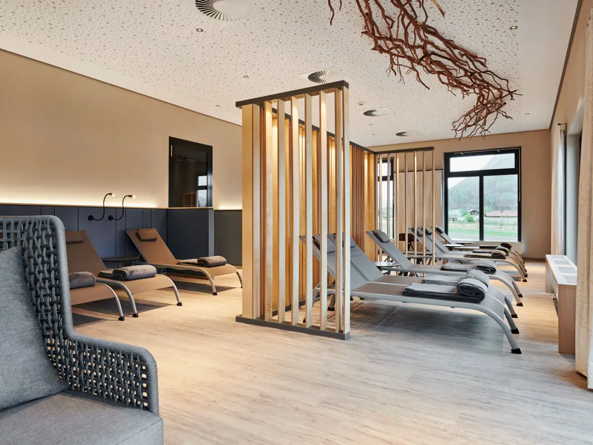 Relaxation area in the sauna landscape A room with lounge chairs and a wooden structure.