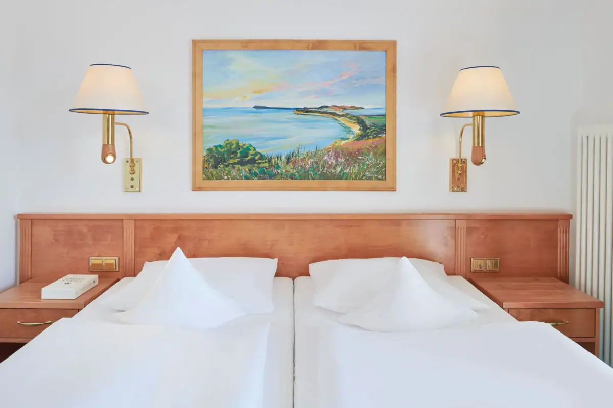 Double room Nordperd & Villas A bed with white sheets and a painting on the wall.