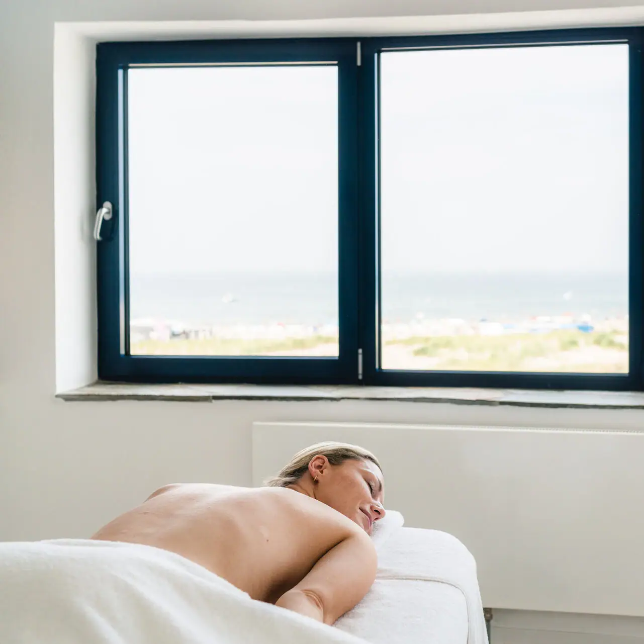 Application room A woman lies on a massage table.