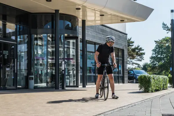 Bicycle hire A man on a bicycle in front of a building.