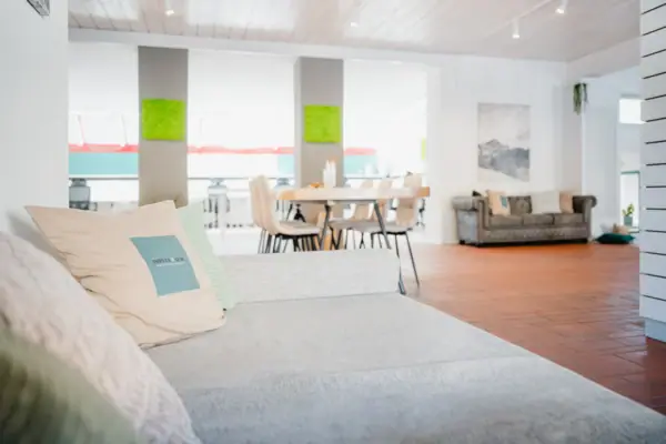 A sofa in a room with cushions on a wooden floor.