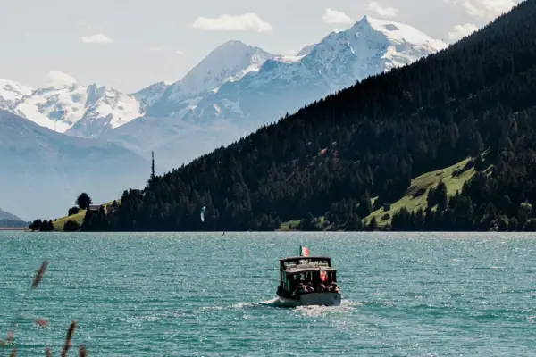 A boat in the water with mountains in the background.