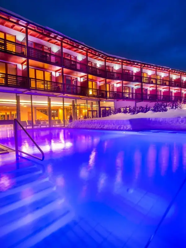 A building with a pool and snow in the foreground.