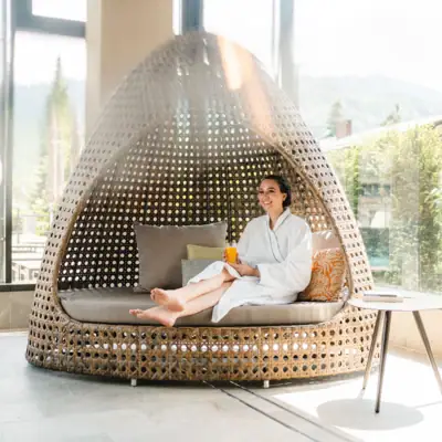 SPA Lounge A woman sits on a wicker chair.
