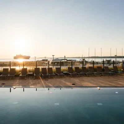 Outdoor pool A pool with chairs and a boat in the background.