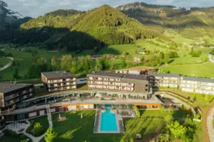 A hotel with a swimming pool set amidst a green field