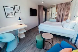 A room with a bed, a table and a chair.