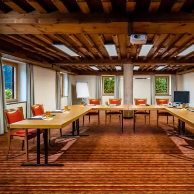 A room with a long table surrounded by chairs.