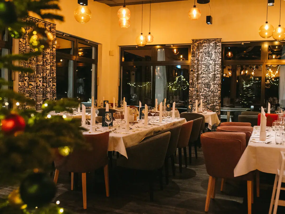 A room with tables and chairs and a Christmas tree.