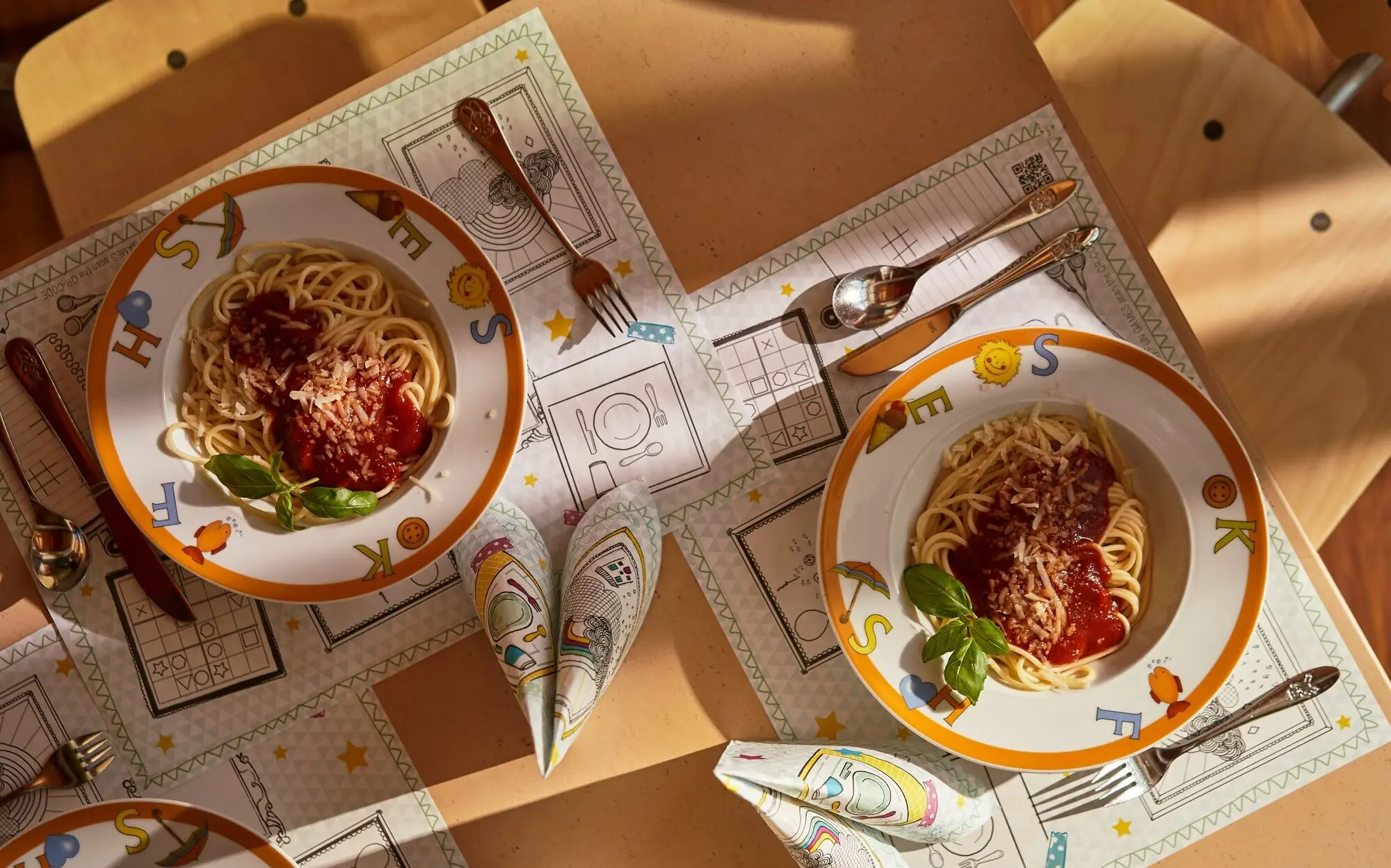 Plate with spaghetti, sauce and cheese on a table.