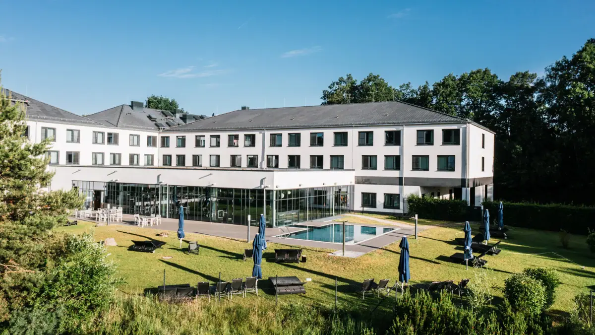 Day SPA in Bad Saarow A building with a pool and outdoor chairs.