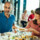 A man and a woman are eating at a table.