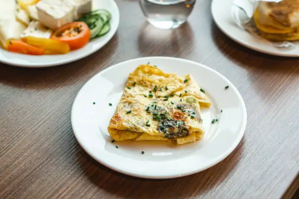 A breakfast table with plates full of food and drinks.