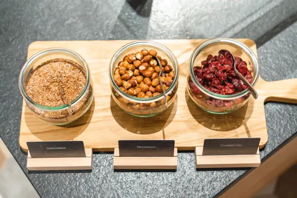 Muesli A group of bowls with food on a wooden board.