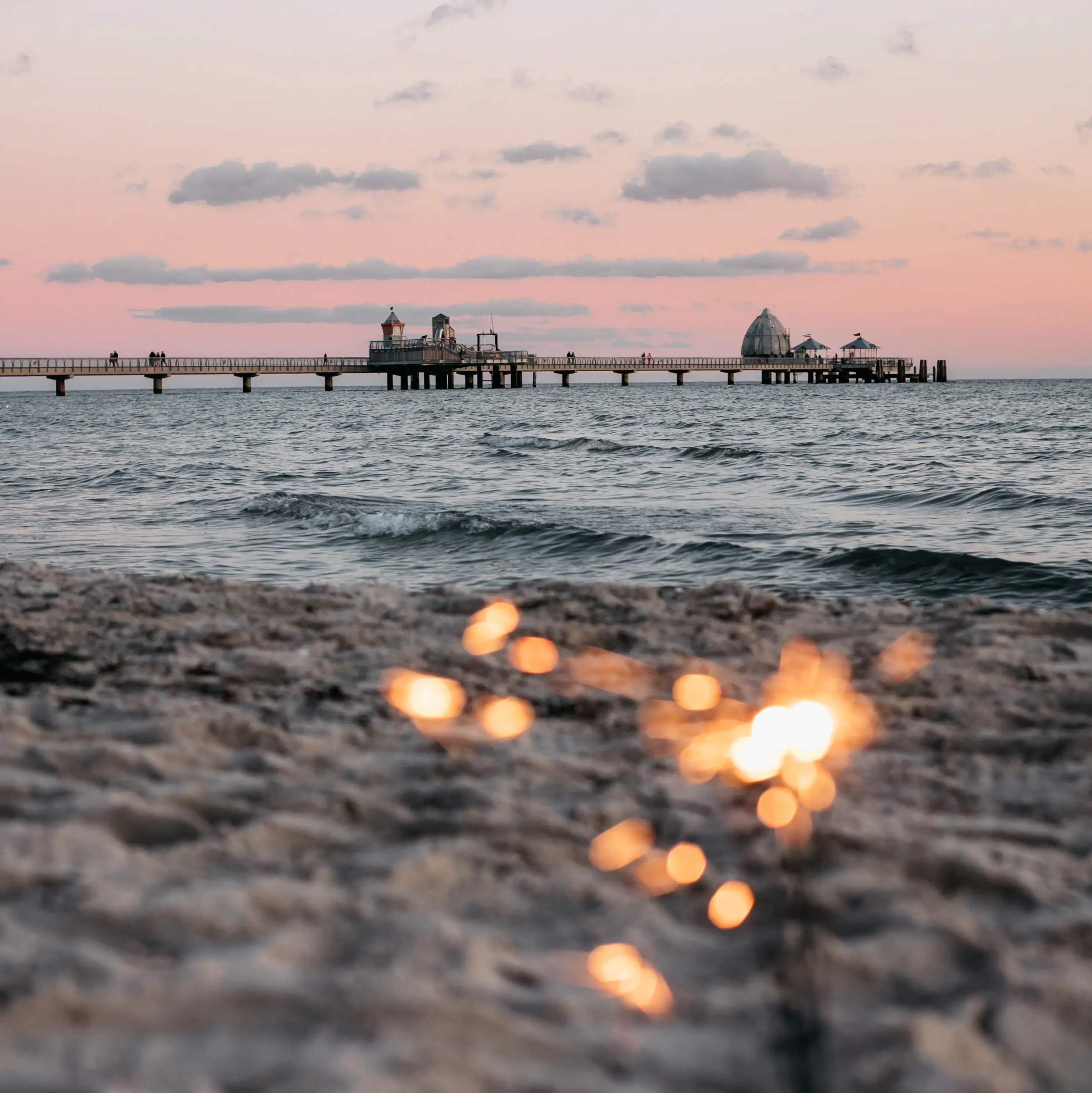 A beach with a pier in the background.