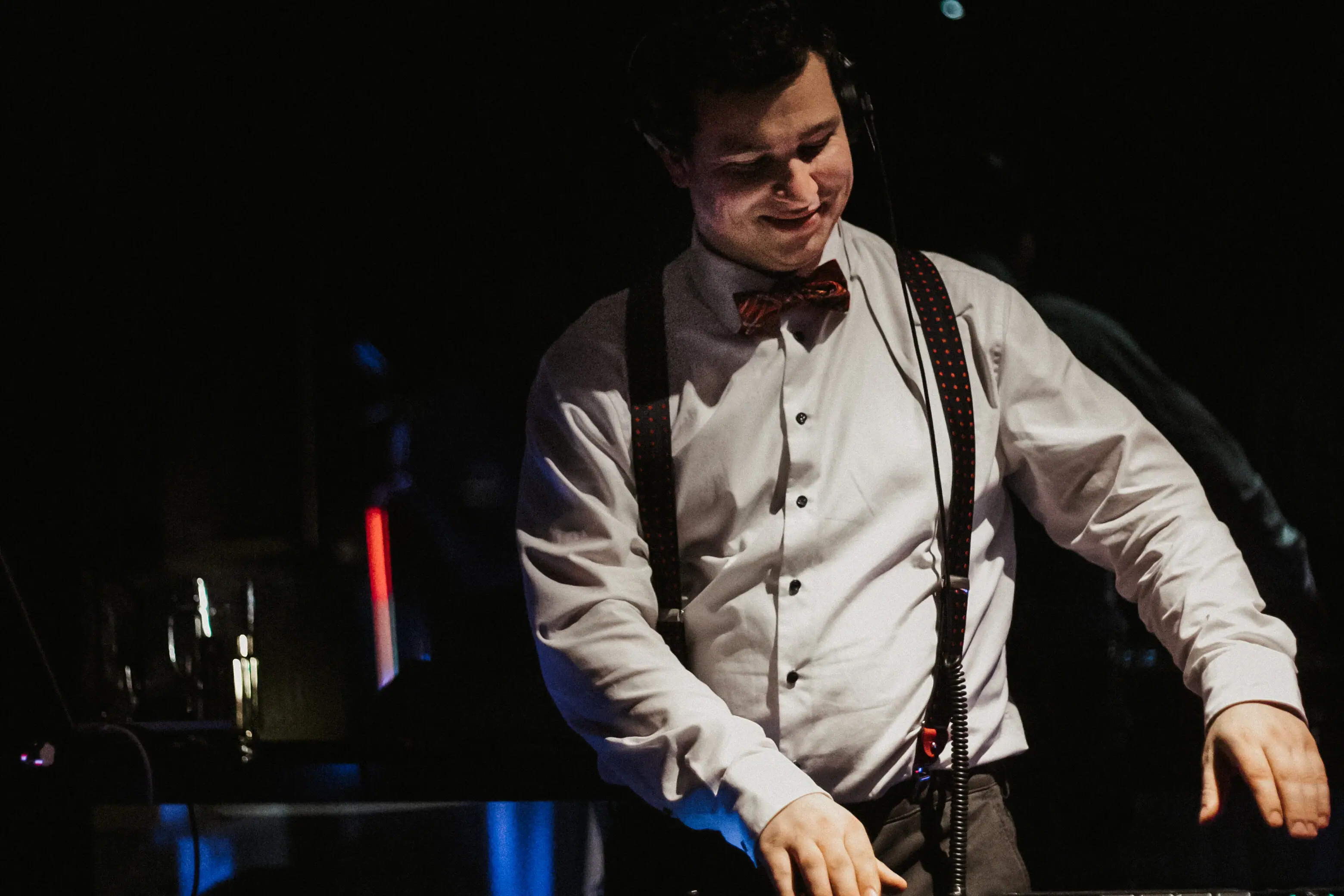 A man wears a bow tie and headphones.