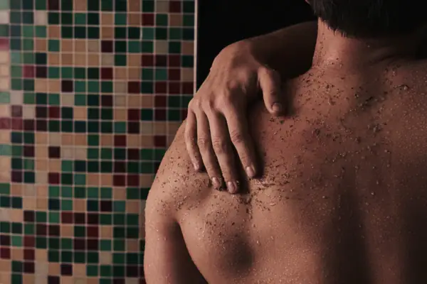 A man with a salt scrub on his back.