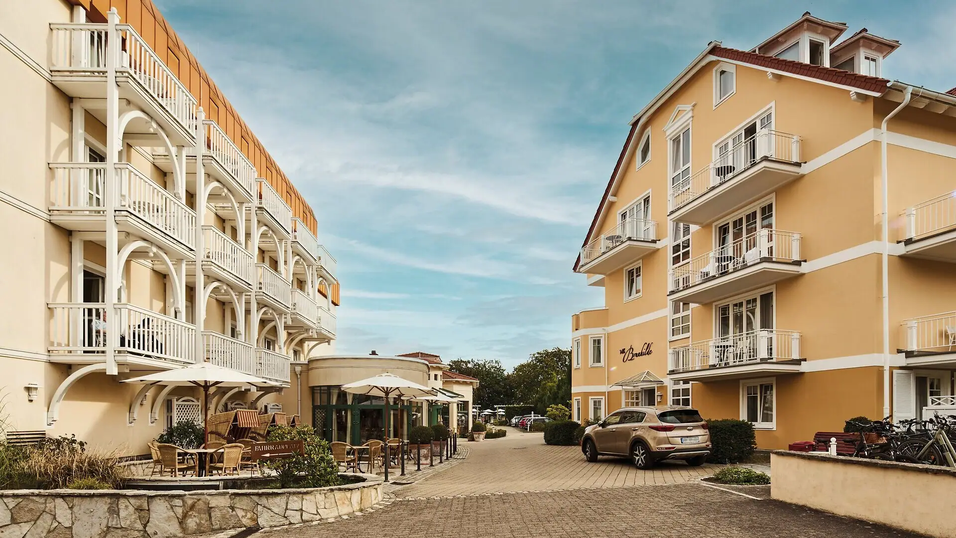 Hotel driveway Street with buildings and parked cars.
