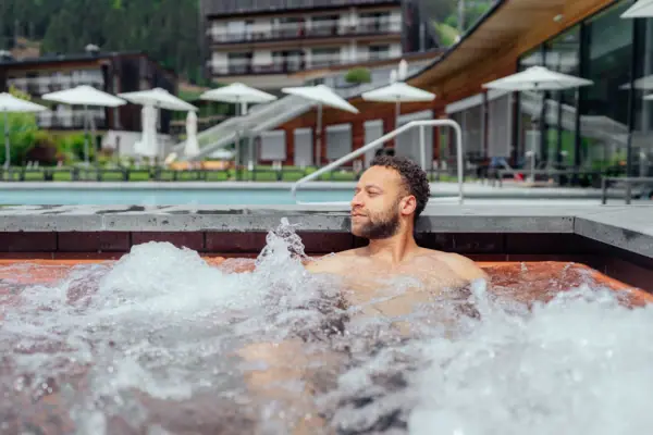 A man in an outdoor hot tub.