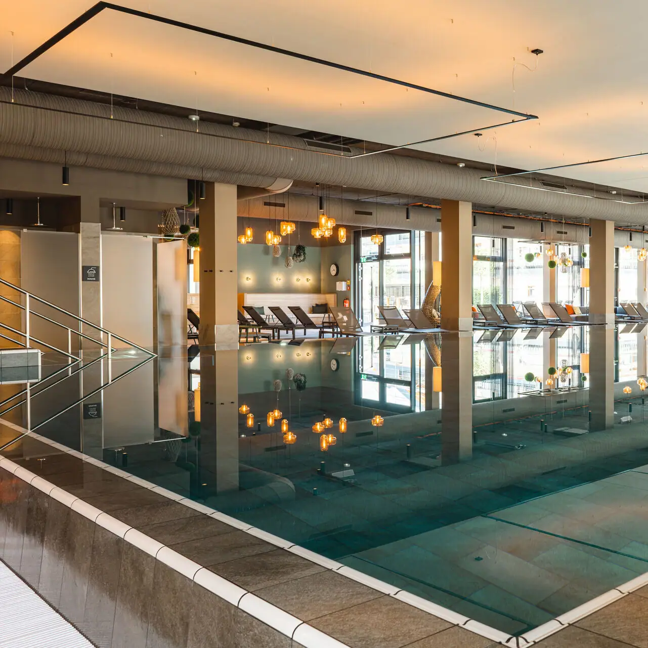 Indoor pool A large indoor pool with chairs and a person standing in the centre.