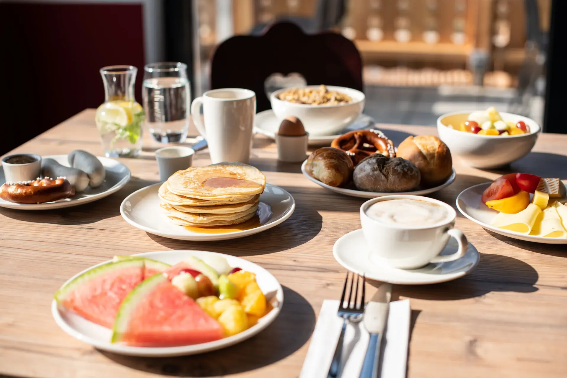 A wooden table with plates full of food and drinks