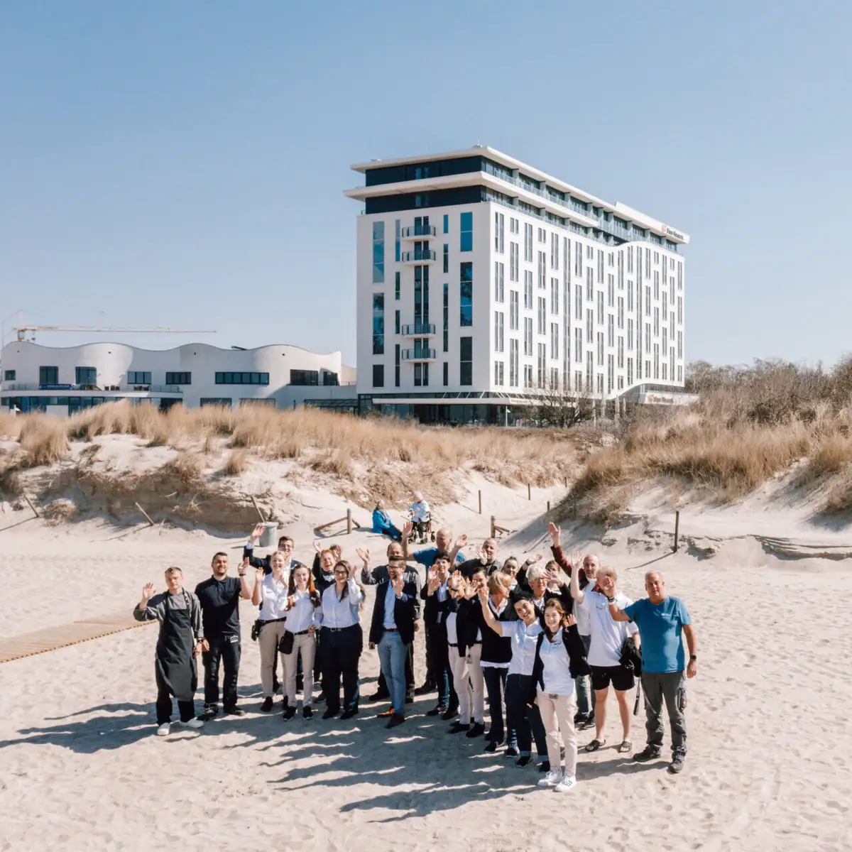 A group of people pose in front of a building.