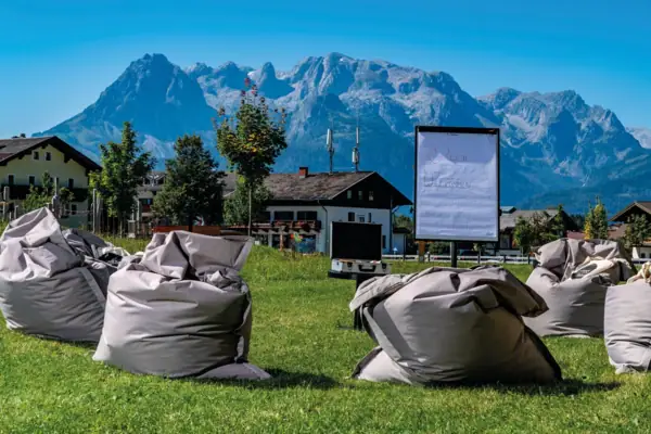 Group of beanbags on a meadow with mountains in the background.