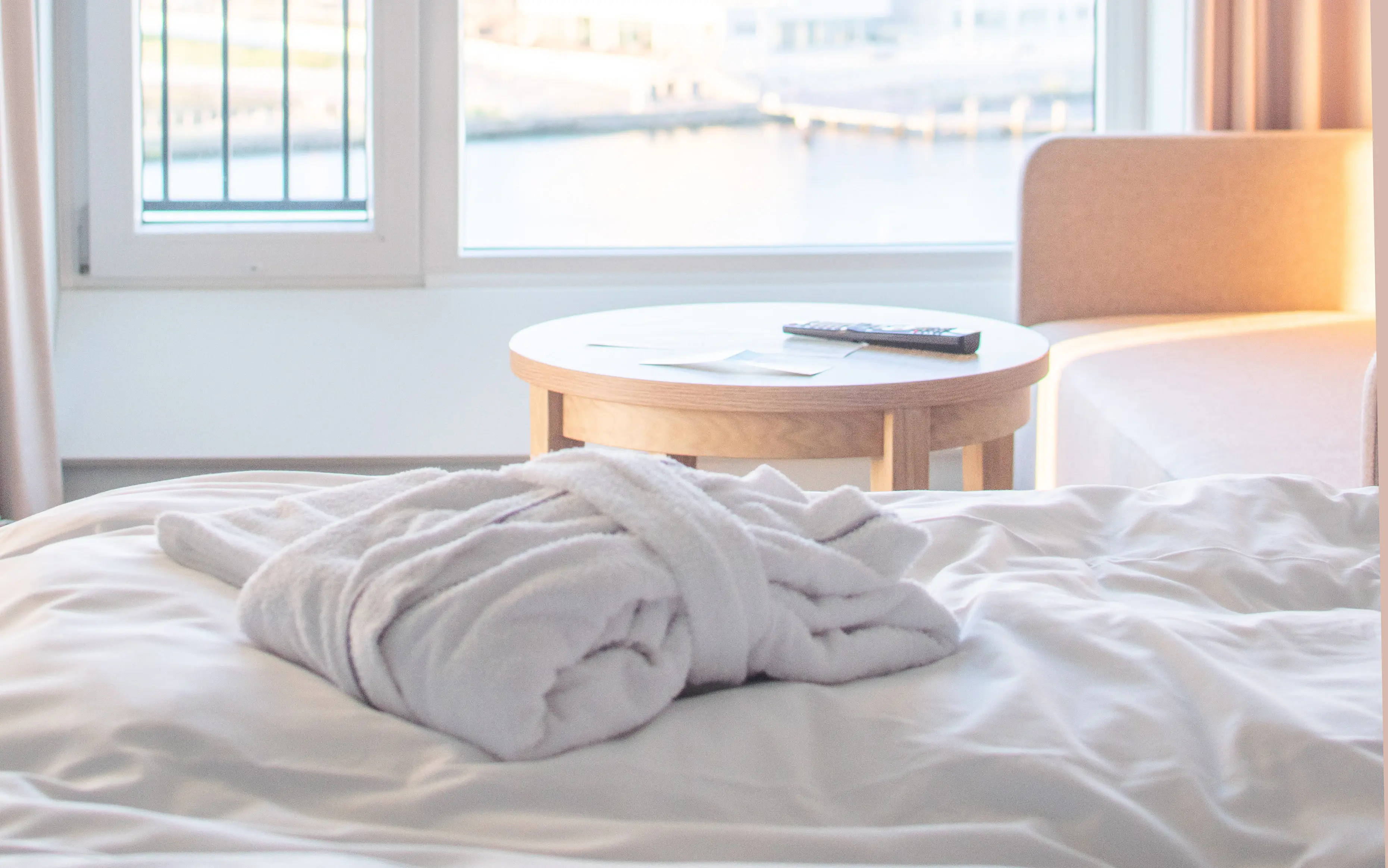 A bathrobe is laying on a bed. 