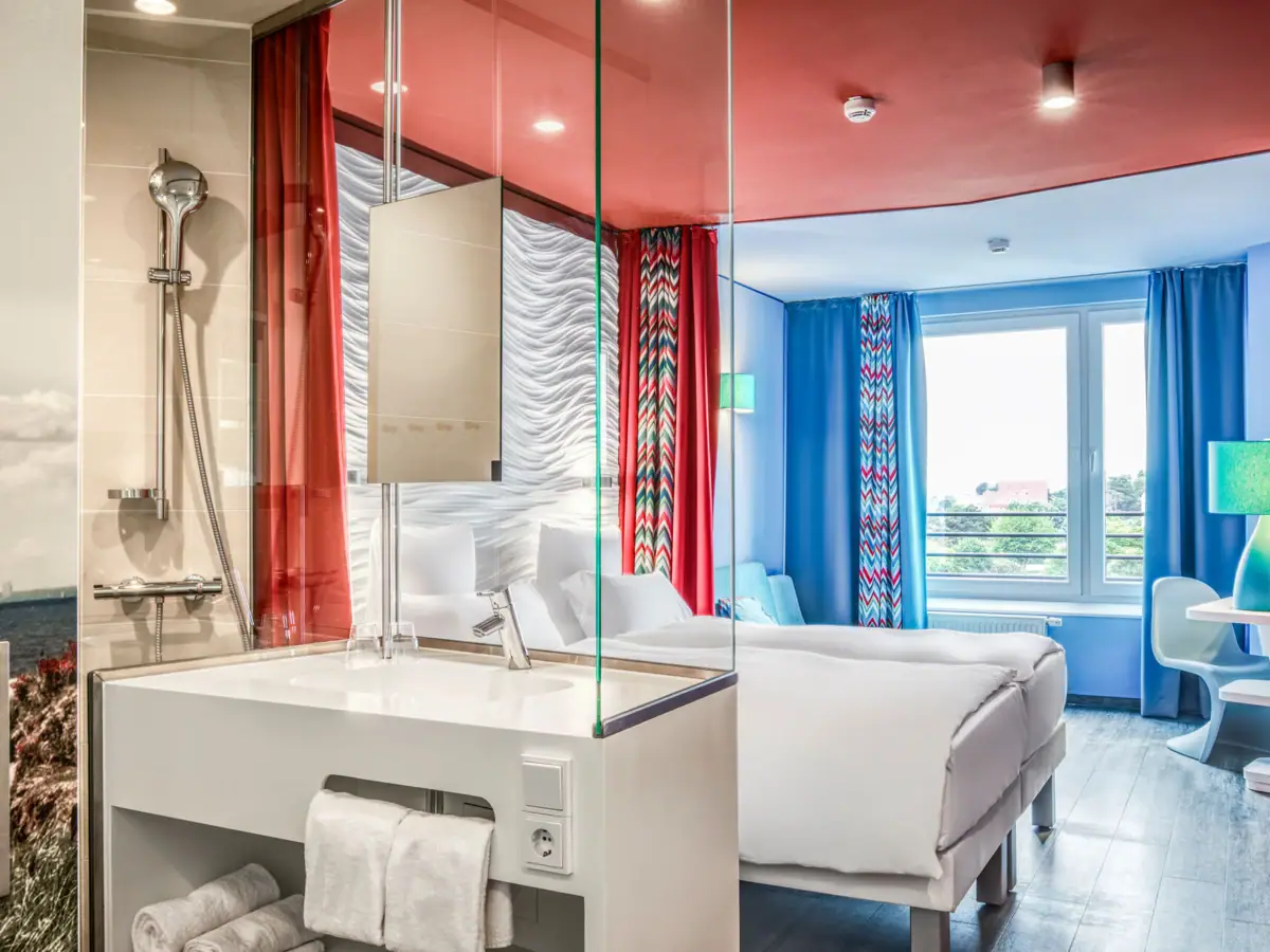 A room with a double bed and a washbasin.