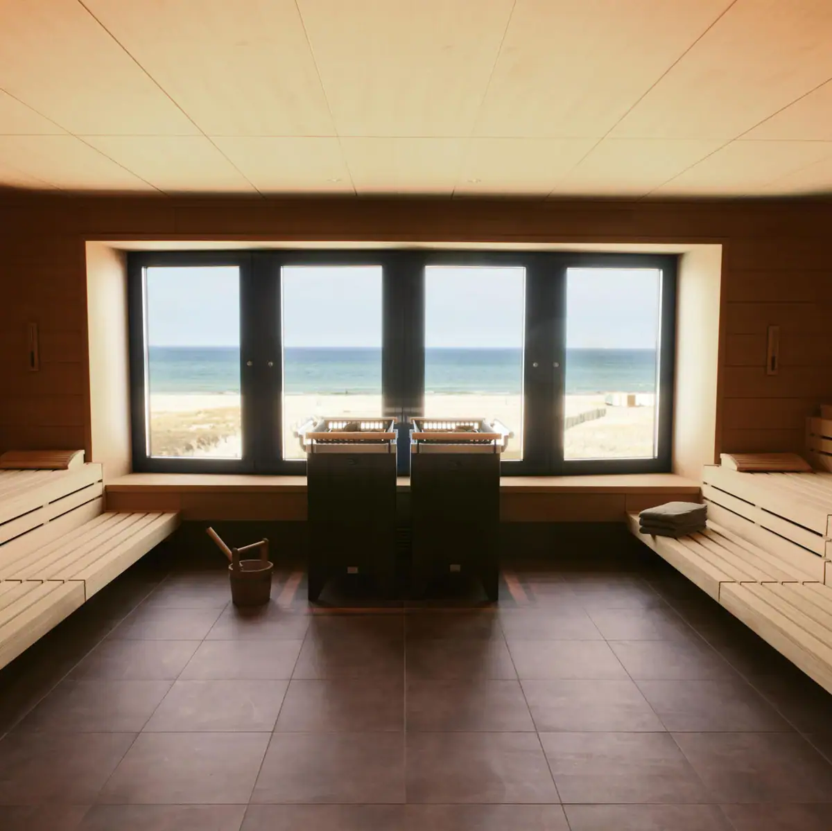 A wooden sauna with a large sea view window. 