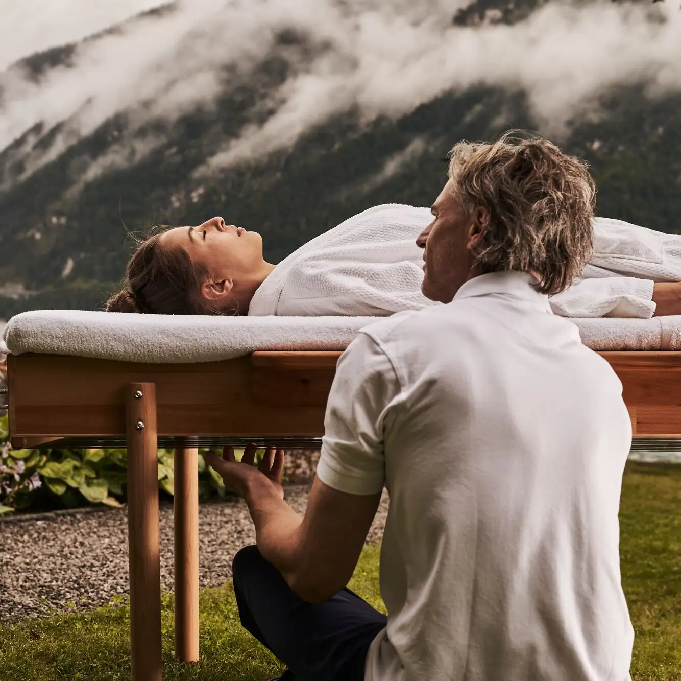 Application A man kneels in front of a table on which a woman is lying.